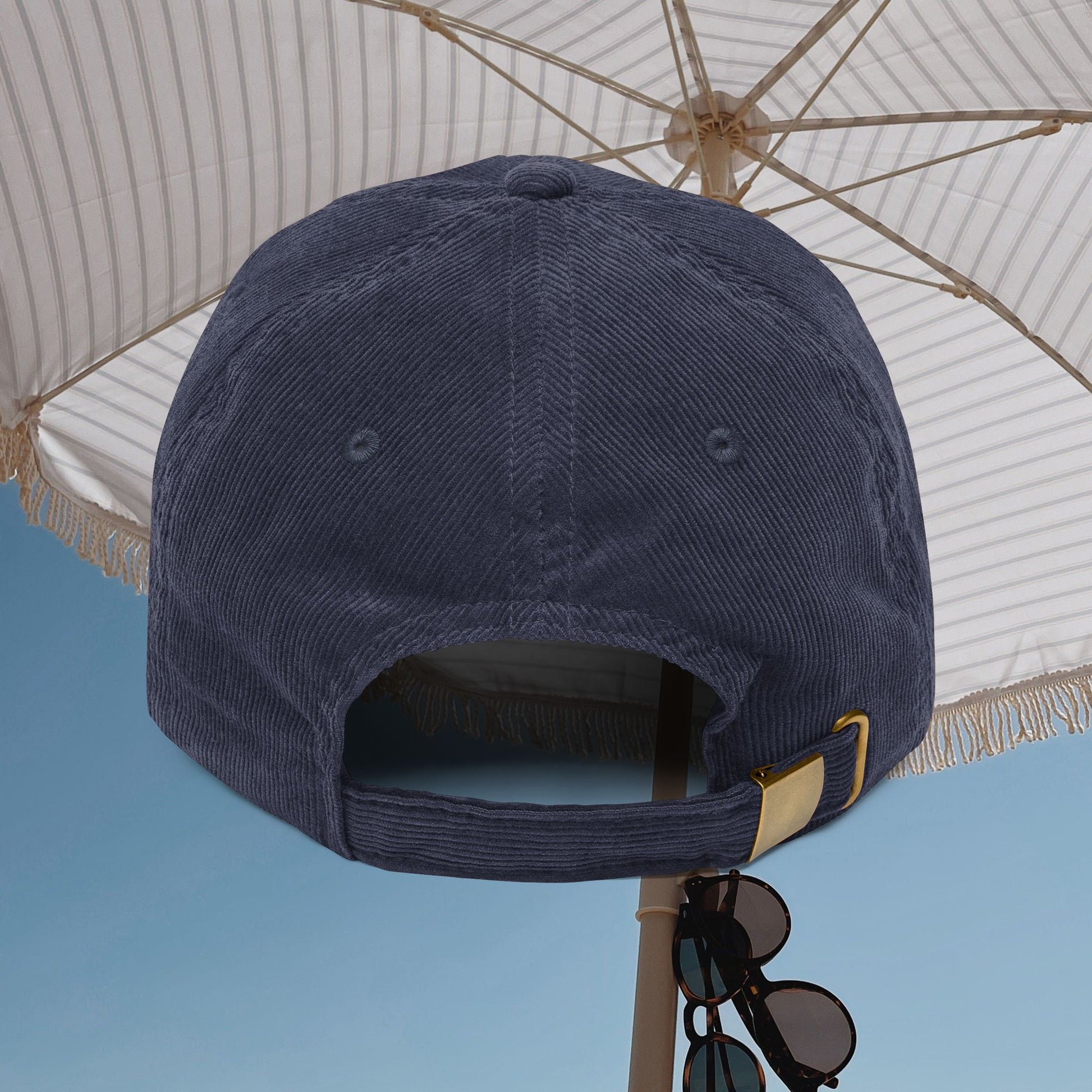 Navy blue cap with a gold buckle on a light blue background